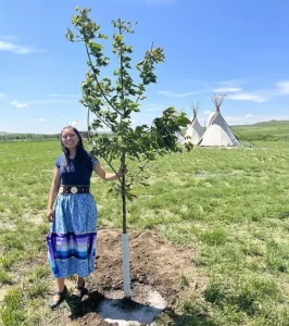 Lakota-Frau pflanzt Baum